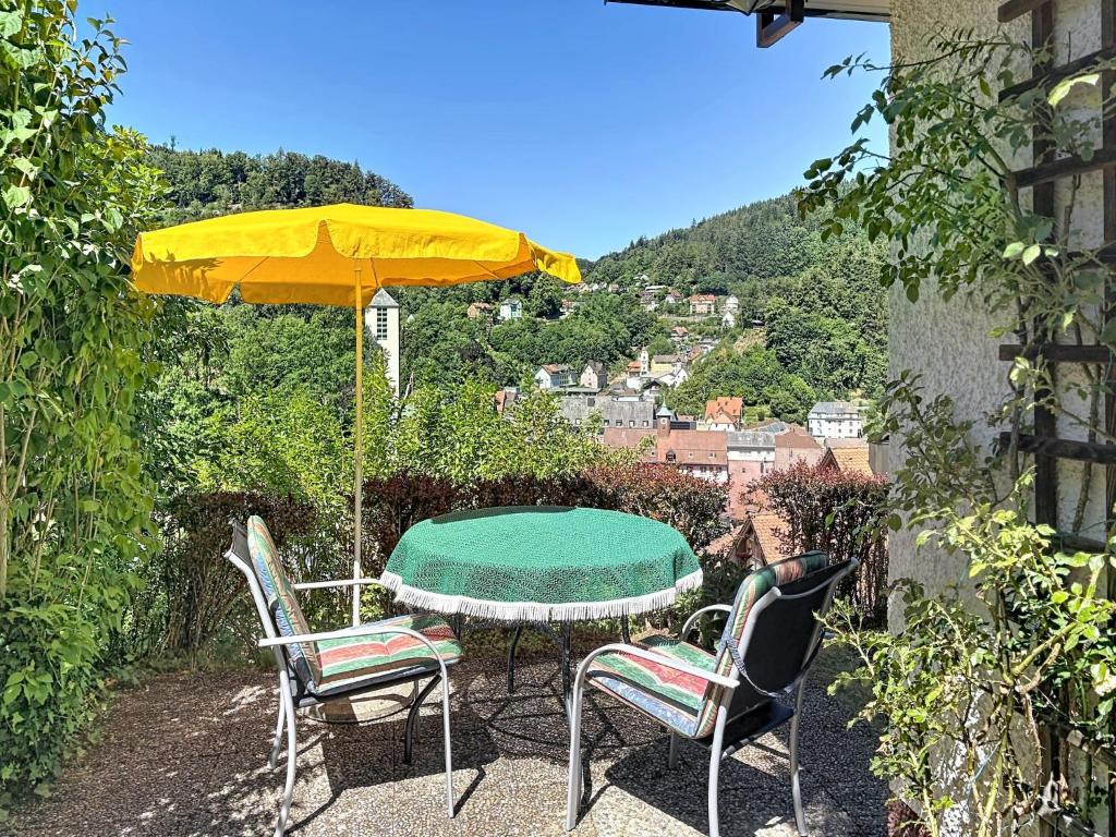 a table with a yellow umbrella and two chairs at Apartment Maier-1 by Interhome in Triberg