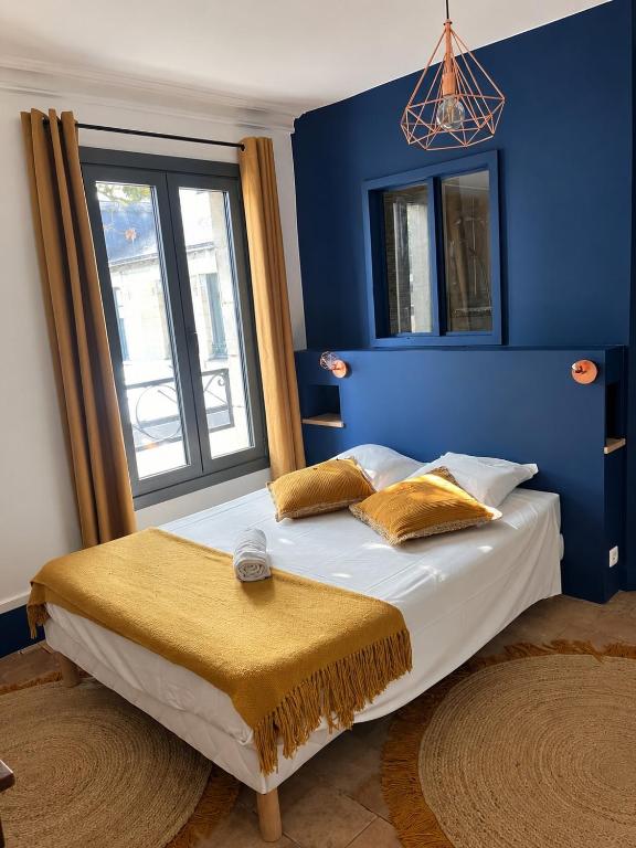 a bedroom with a bed with a blue wall at Le Garage, La Chambre in Fontevraud-l'Abbaye