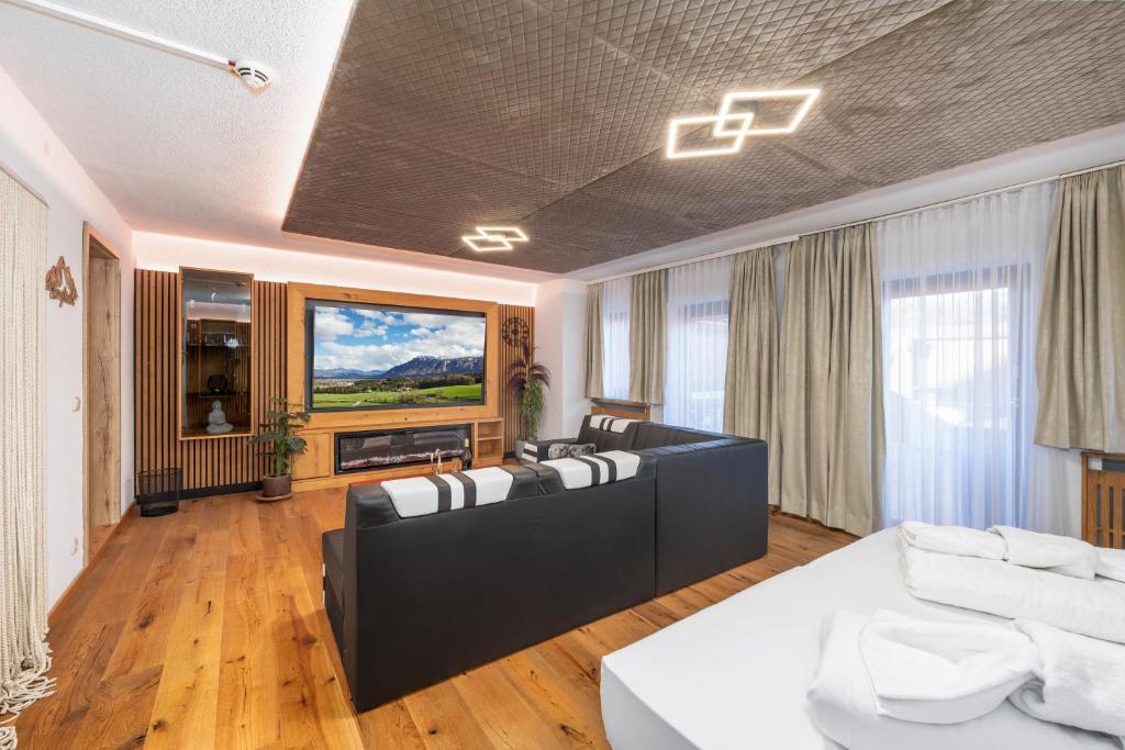 a living room with couches and a large painting on the wall at Luxus Suite mit Whirlpool im Hotel Rupertihof in Ainring