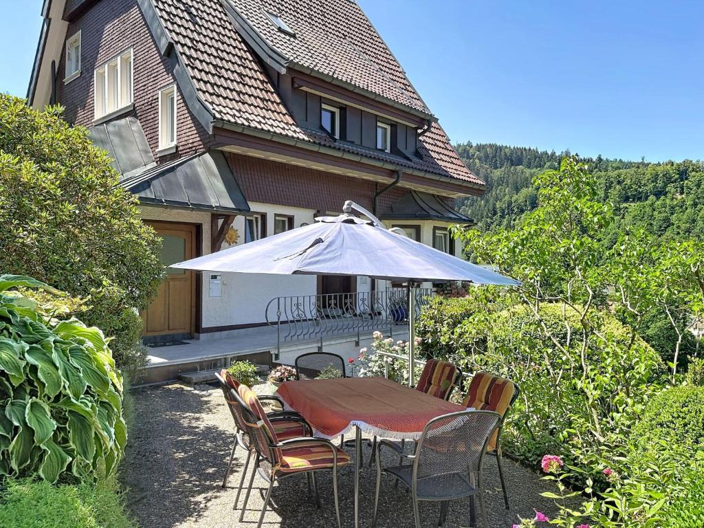 a table with an umbrella in front of a house at Apartment Maier-2 by Interhome in Triberg