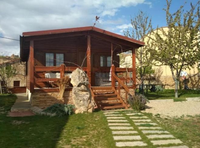 a wooden cabin with a staircase in a yard at Apartamento El Paso in Fuentelisendo