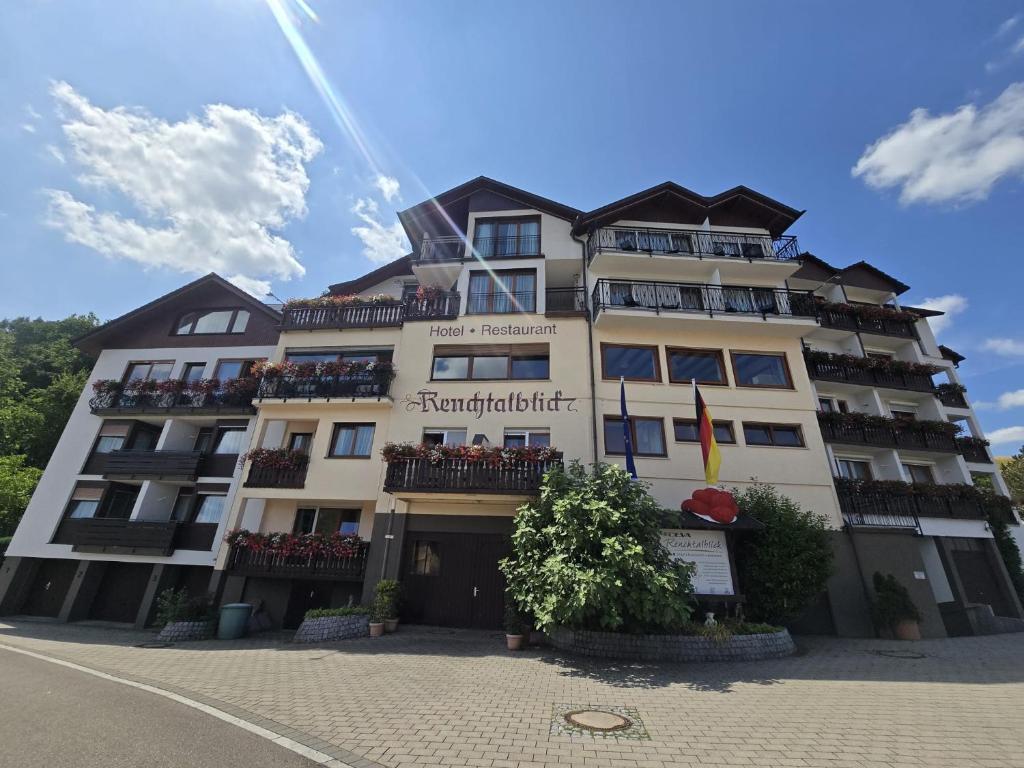 a large white building with balconies on a street at DEVA Hotel Renchtalblick in Oberkirch