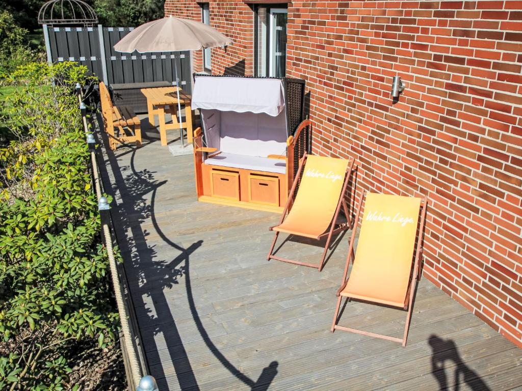 two chairs and an umbrella on a patio at Holiday Home Weideblick by Interhome in Geestland