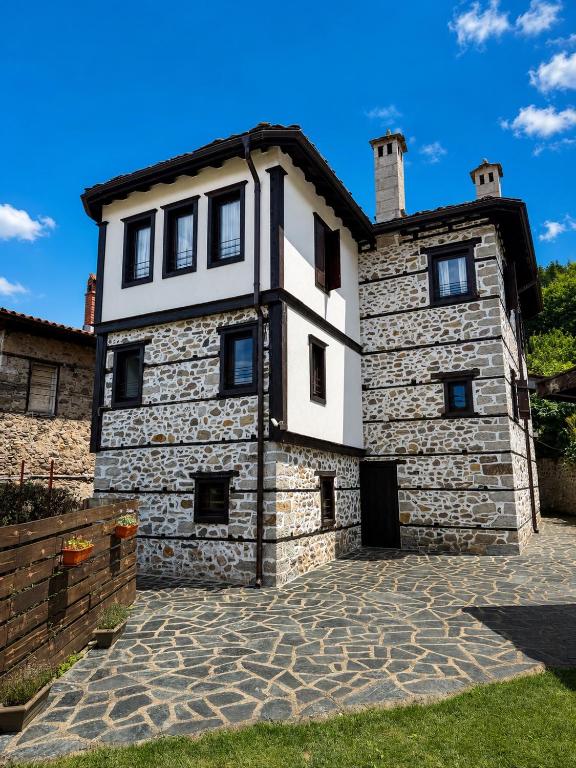 an old stone house with a stone driveway at Къща за гости Родопчани in Smolyan
