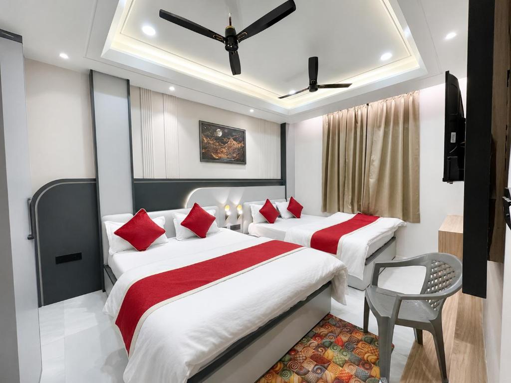 a hotel room with two beds with red pillows at NEAR SHREE RAM JANM BHOOMI - HOTEL SHREE RR - Wi-Fi - Parking- Luxury Rooms - Best Family Hotel In Ayodhya in Ayodhya