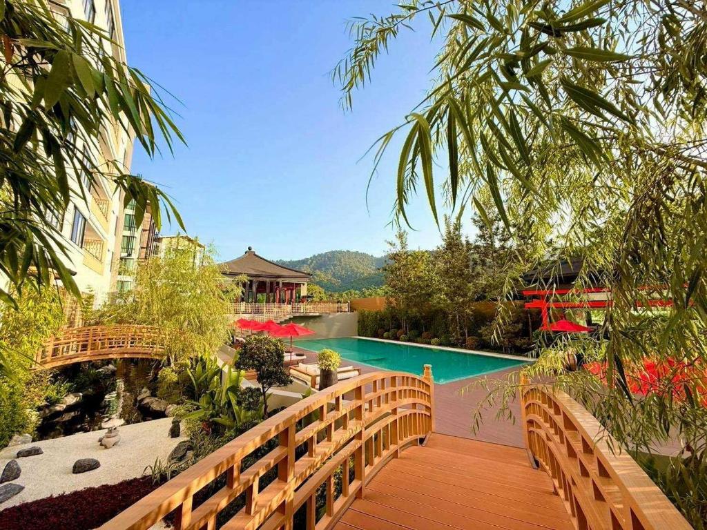 a wooden walkway leading to a swimming pool at Zen Essence Khao Yai in Khao Yai