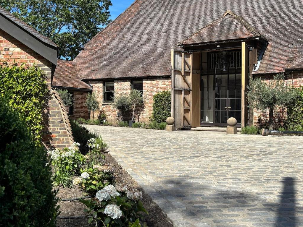 a brick building with a large glass door at Surrey Barn, Newly Renovated in Ripley