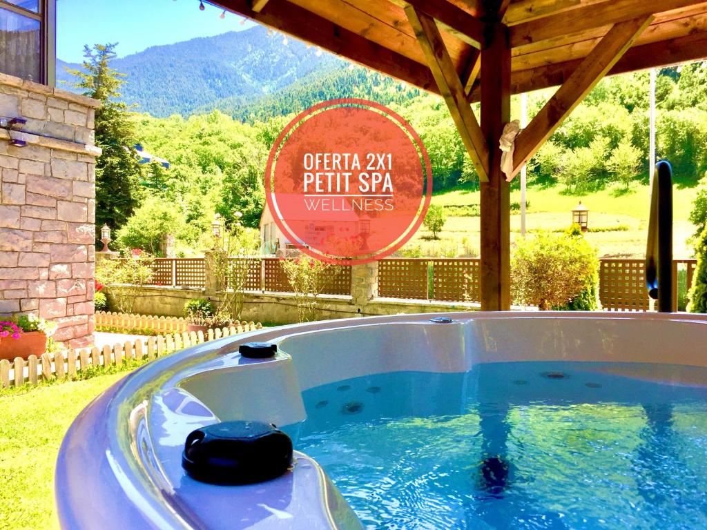 a hot tub in a yard with a sign at GRAN CHALET HOTEL & PETiT SPA WELLNESS in Vielha