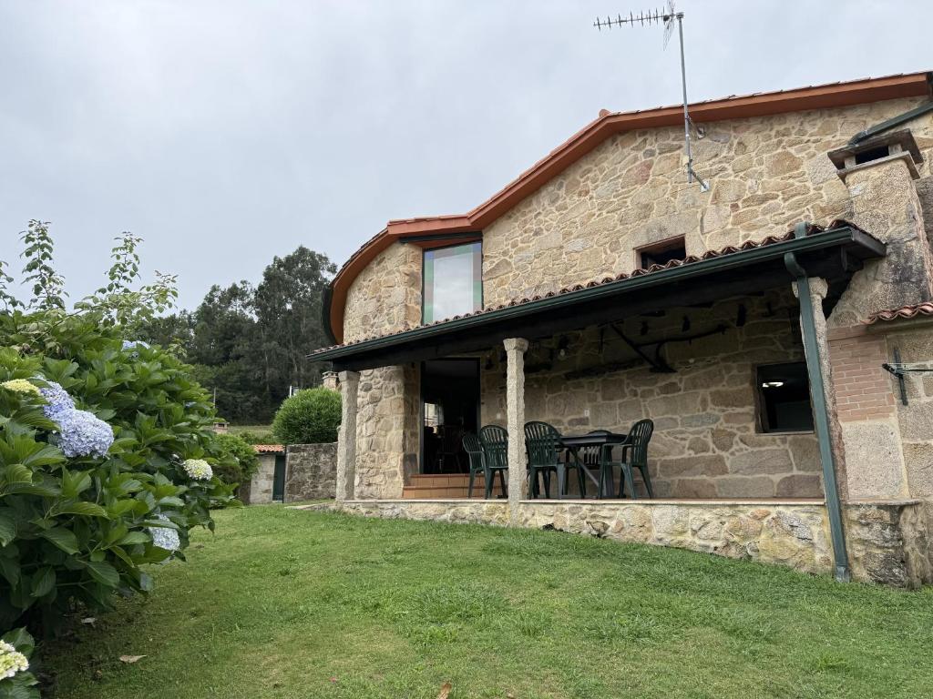 an outside view of a stone house with a patio at BLEU MAISON-PAZO 2 CL in Campo Lameiro