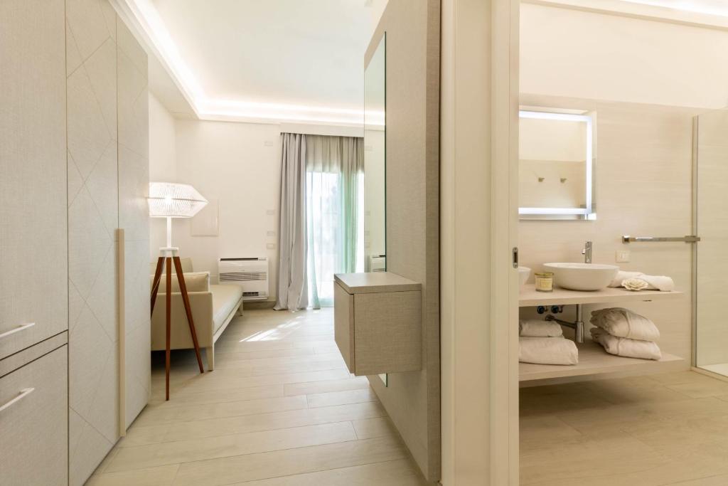 a white bathroom with a sink and a mirror at Affittacamere Mare Poetto Cagliari in Quartu Sant'Elena