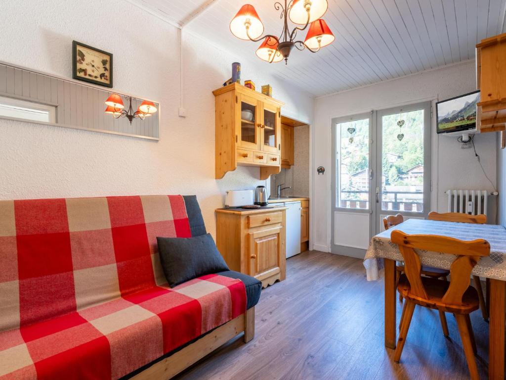a bedroom with a bed and a table and a kitchen at Appartement au cœur de La Clusaz, animaux acceptés - FR-1-304-7 in La Clusaz