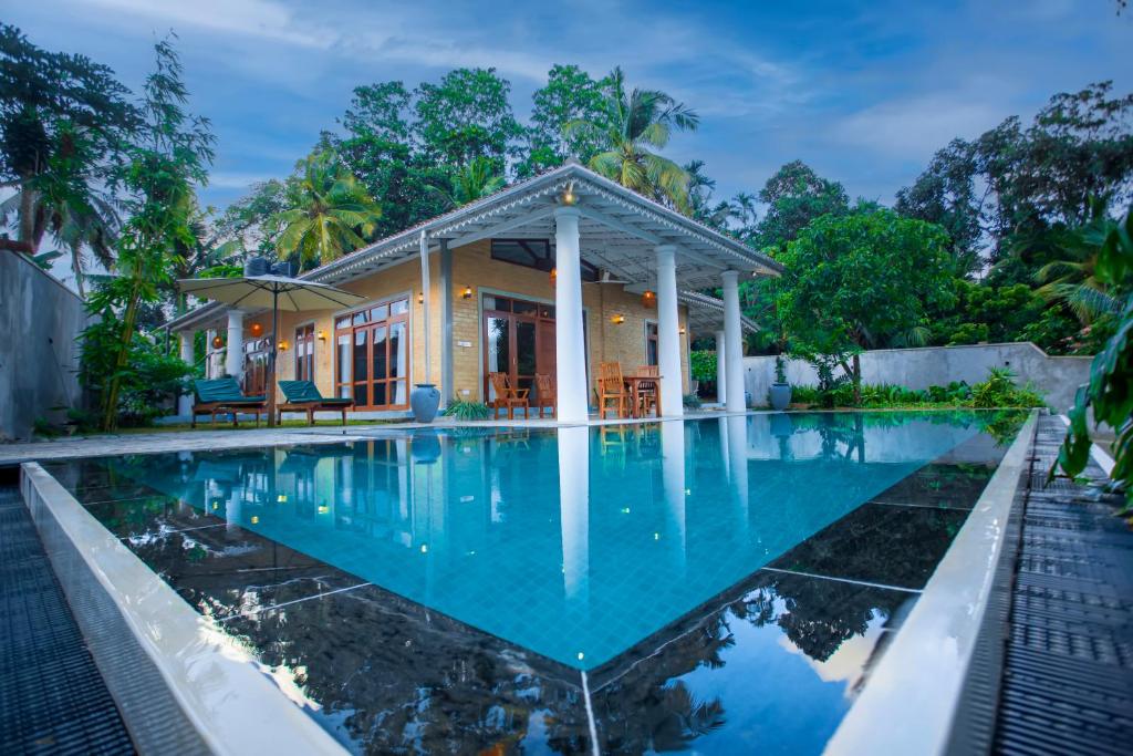 a house with a swimming pool in front of it at Legato House in Talpe
