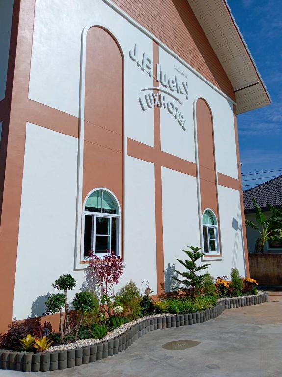 a church with a cross on the side of it at โรงแรม JP Lucky Lux Hotel in Ban Nong Samran