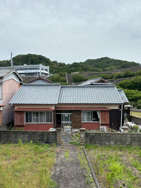 a red house with a fence in front of it at ゲストハウス奥白浜 in Shirahama