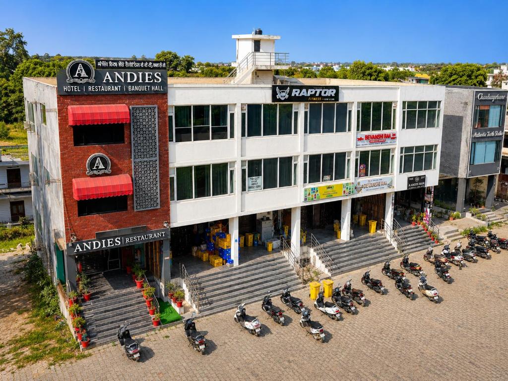 a building with a bunch of motorcycles parked in front of it at Hotel Andies in Mohali