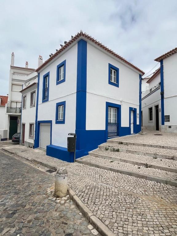 a blue and white house on a cobblestone street at Refugio dos Lima in Ericeira