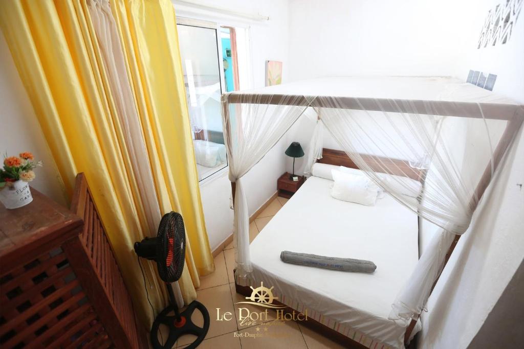 a small bedroom with a bunk bed with a remote control at Le Port Hotel in Fort Dauphin