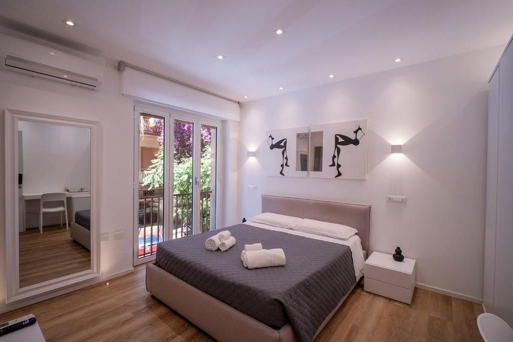 a bedroom with a bed with two towels on it at ABBA ROOMS in Cagliari