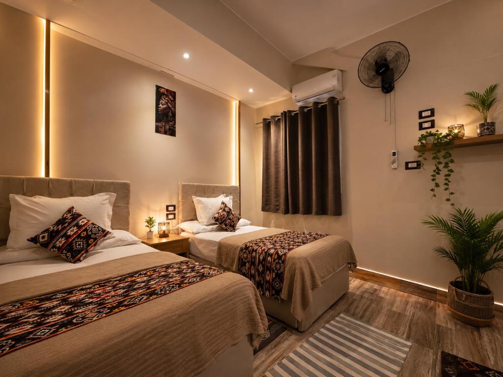 a hotel room with two beds and a window at Grand Duplex in Aswan