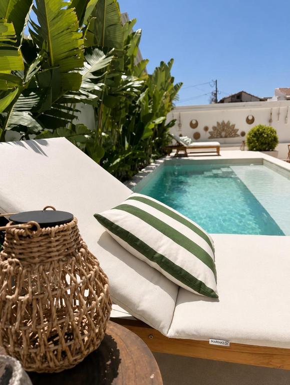 a white couch with a pillow next to a swimming pool at Villa Rafa in Costa Nova