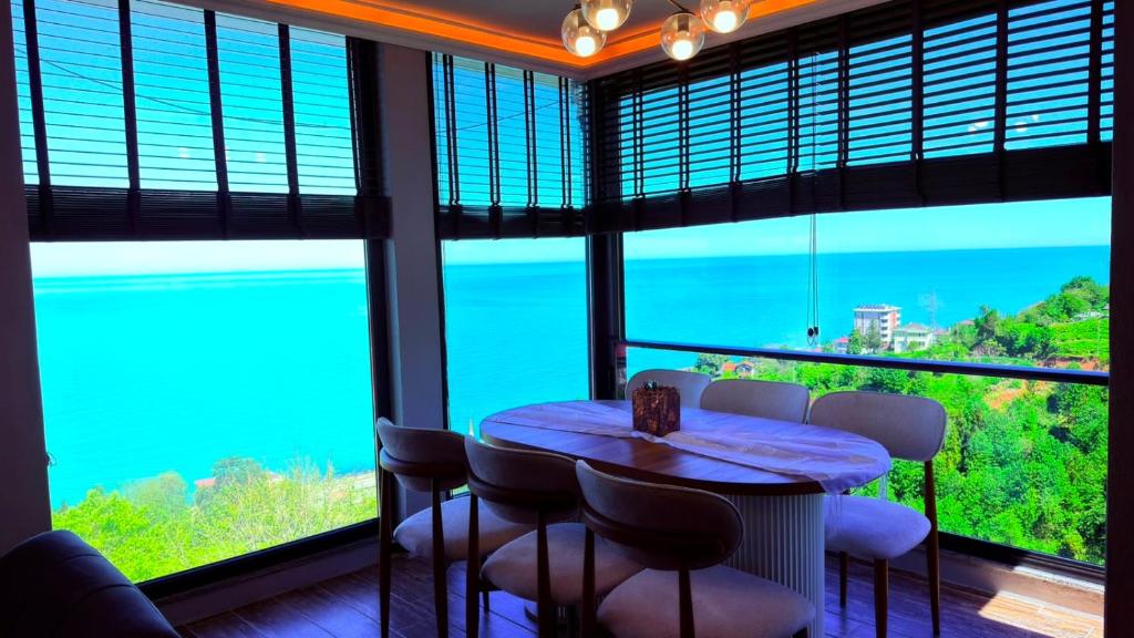 a room with a table and chairs and a large window at cam teras villa in Cayeli