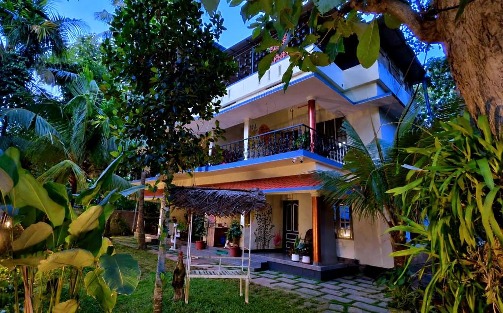 a house with a balcony and a yard at Aryavilla Heritage in Varkala