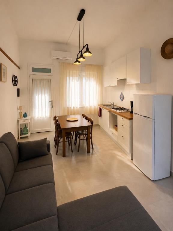 a kitchen and a living room with a couch and a table at Valledoria Central Modern Studio in Valledoria