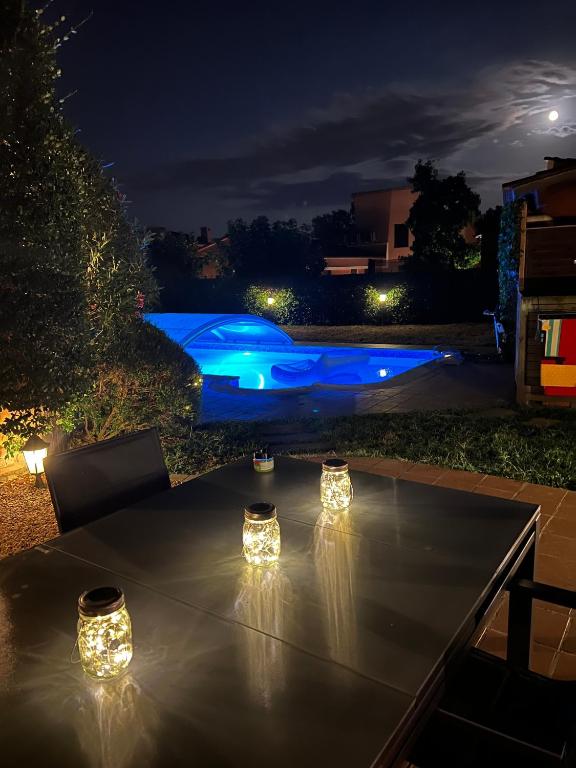 a table with lights on a patio at night at Cal Piano in Palol de Rebardit