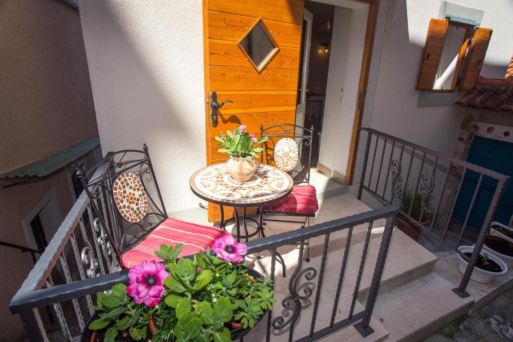 a balcony with a table and chairs and a wooden door at Holiday Home Smokovec in Vrbnik