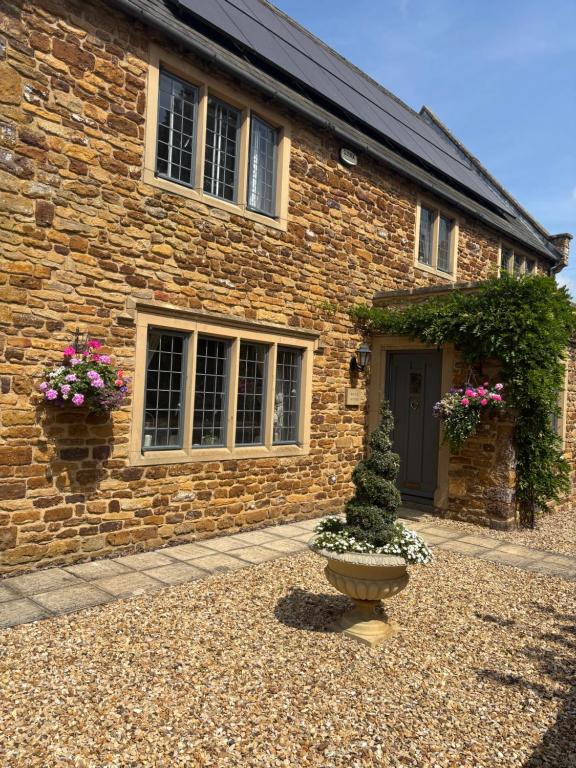 a brick house with a plant in front of it at Maple House in Faxton