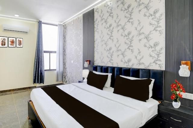 a bedroom with a large bed with a blue headboard at HoTEL KAMAL VINTAGE in Kāthgodām