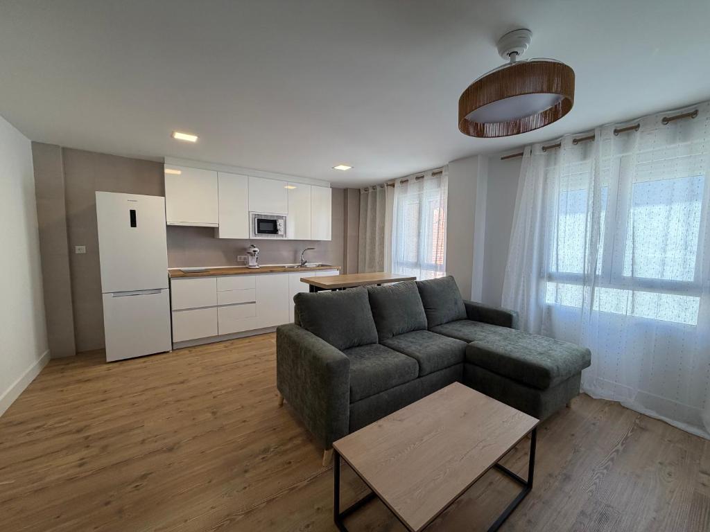 a living room with a couch and a kitchen at AMANITA VuT in Huerta del Rey