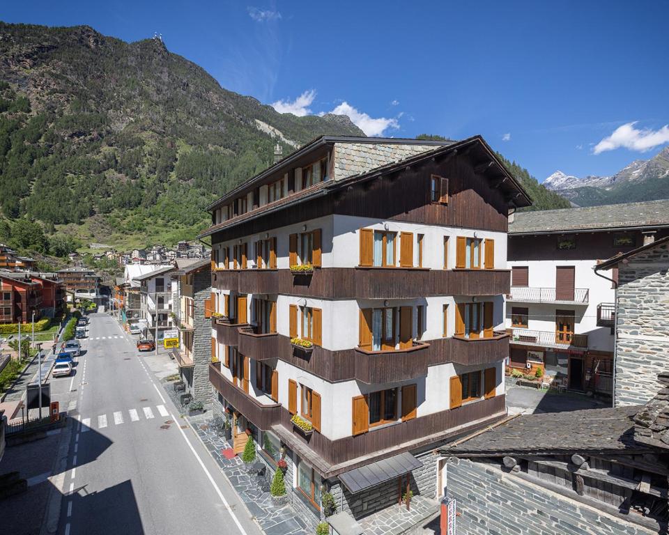 a building on the side of a street with a mountain at Hotel Funivia in Chiesa in Valmalenco