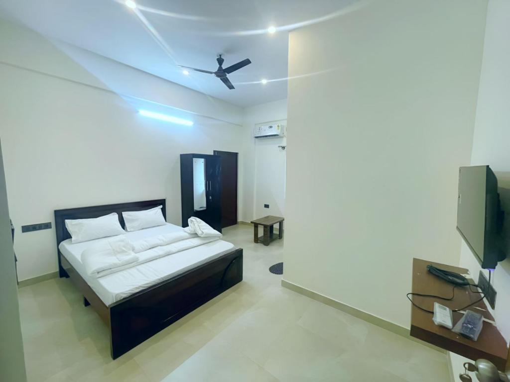 a bedroom with a bed and a ceiling fan at GR Comforts Boarding and Lodging in Hirehalli