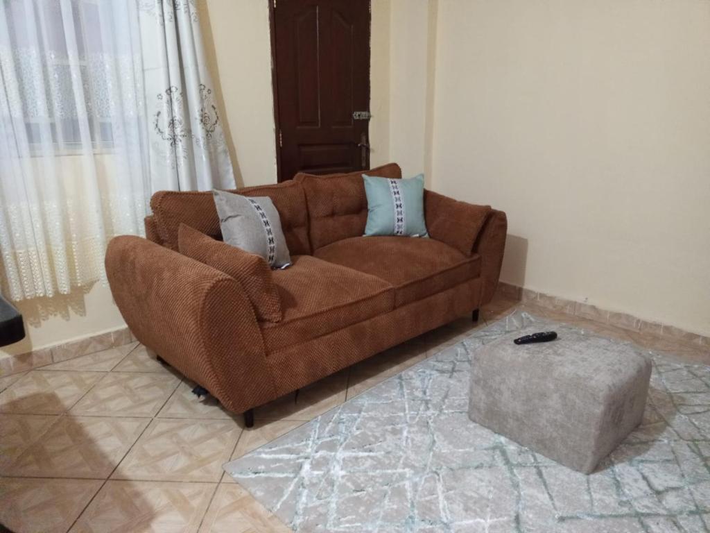 a brown couch sitting in a living room at Voi town CBD homes in Voi