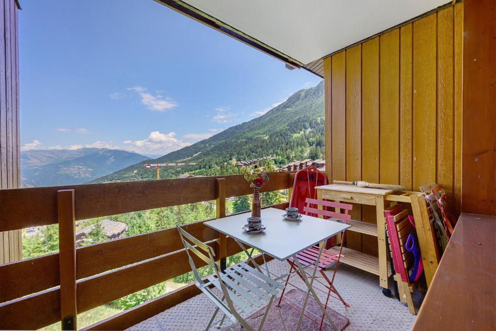 a balcony with a table and chairs and a view at Grand studio Cosy divisible in Valmorel