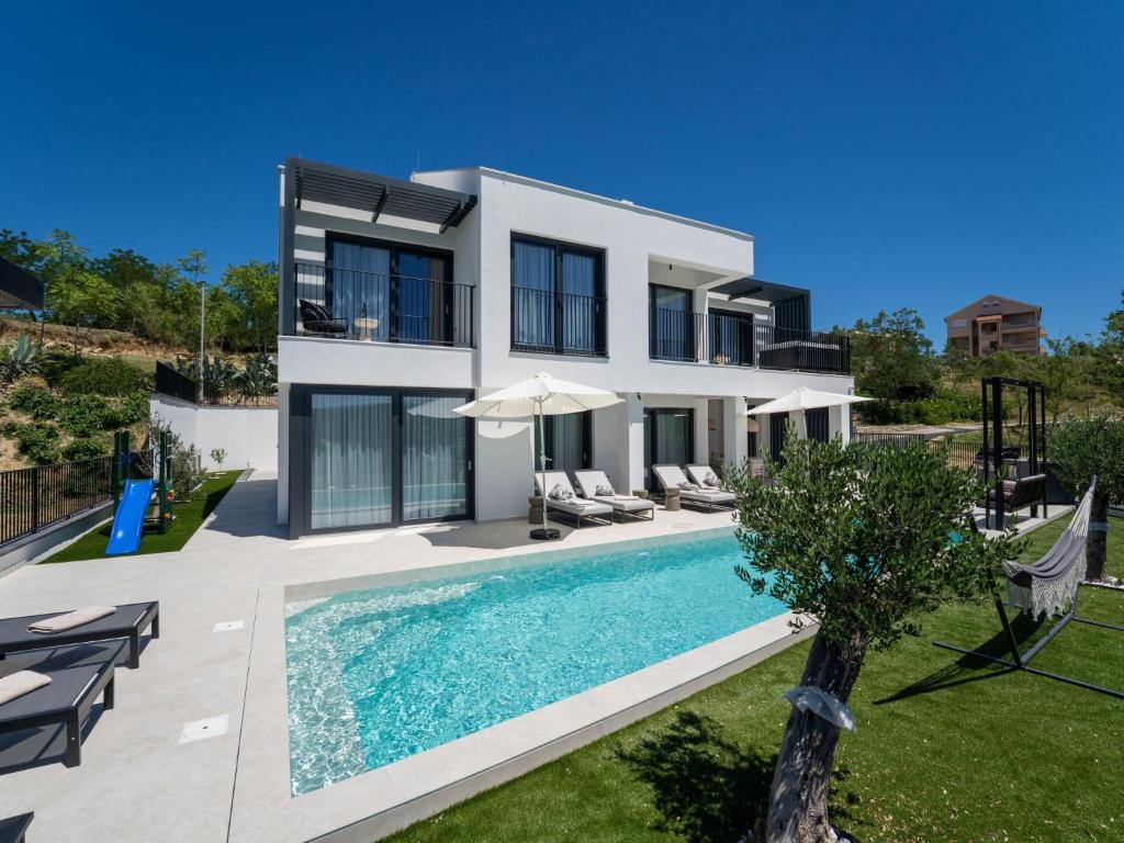 a villa with a swimming pool and a house at Villa Loparia by Interhome in Lopar