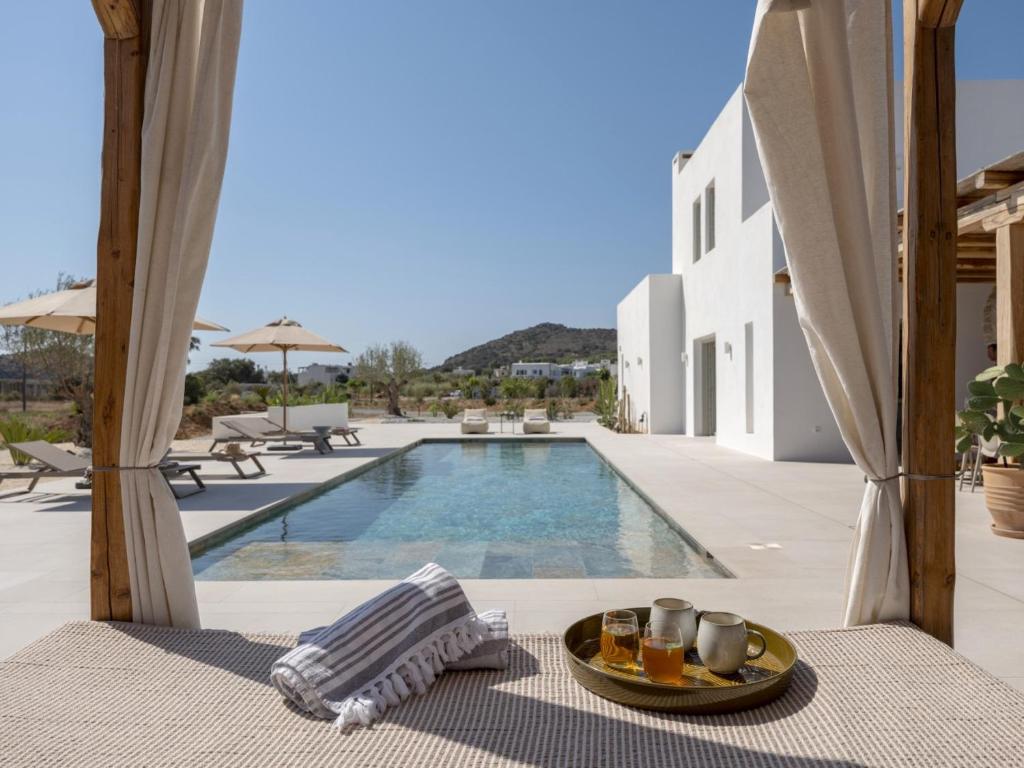 a table with a plate of food next to a swimming pool at Villa Bema - Quietness and Beach access in Molos Parou