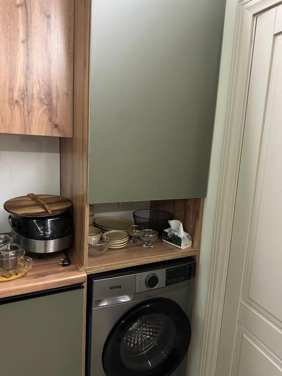 a kitchen with a washing machine in a kitchen at Ademi cottage in Koshkolʼ