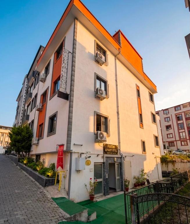 a white building with an orange roof on a street at miamia apart otel in Trabzon