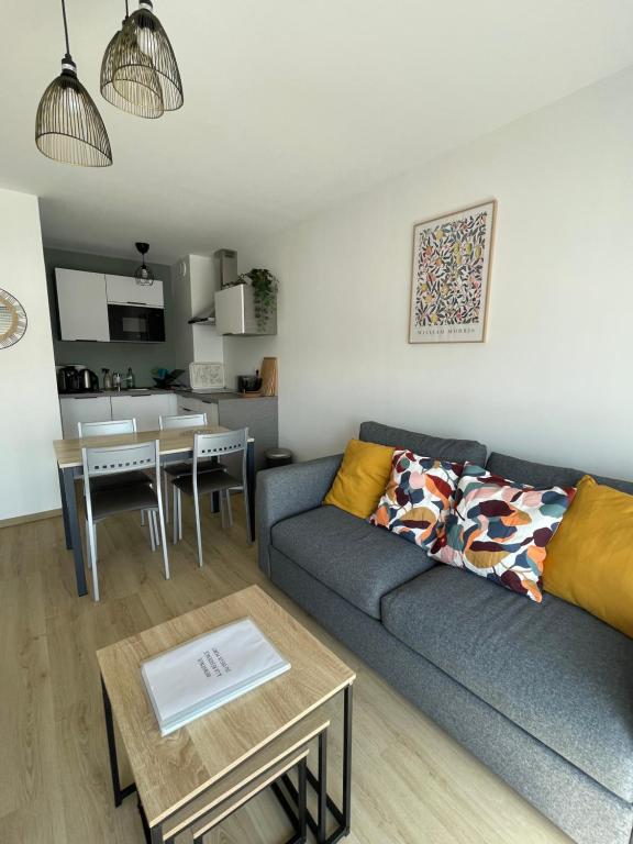 a living room with a couch and a table at Une jolie vue - Appt 2 pièces - Vue mer Balcon sud - 150m de la plage in Wimereux