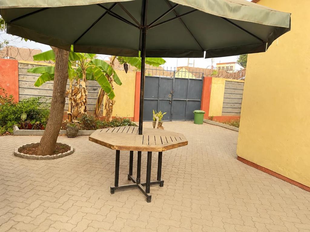 a picnic table with an umbrella on a patio at Nest at Imaara in Nairobi