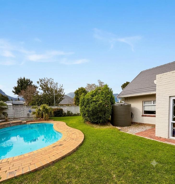 a swimming pool in the yard of a house at Three on Firmount in Somerset West