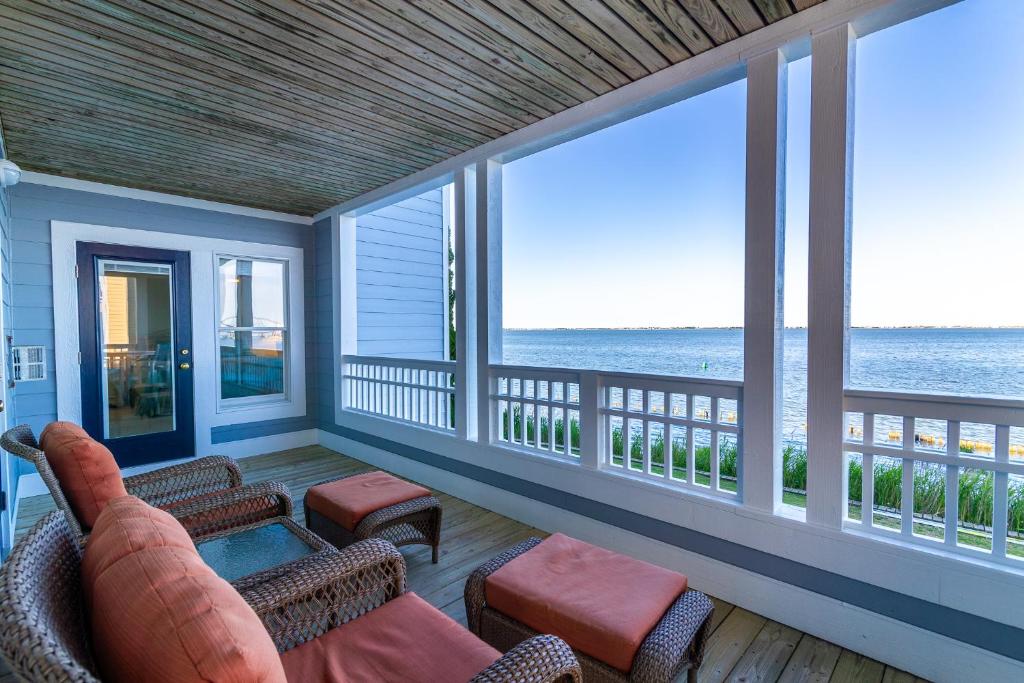 a porch with a couch and chairs and the ocean at BCBPV1411 Ballast Point in Manteo