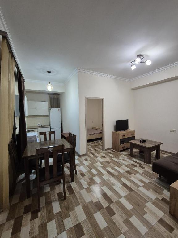 a living room with a table and a kitchen at At home in Yerevan