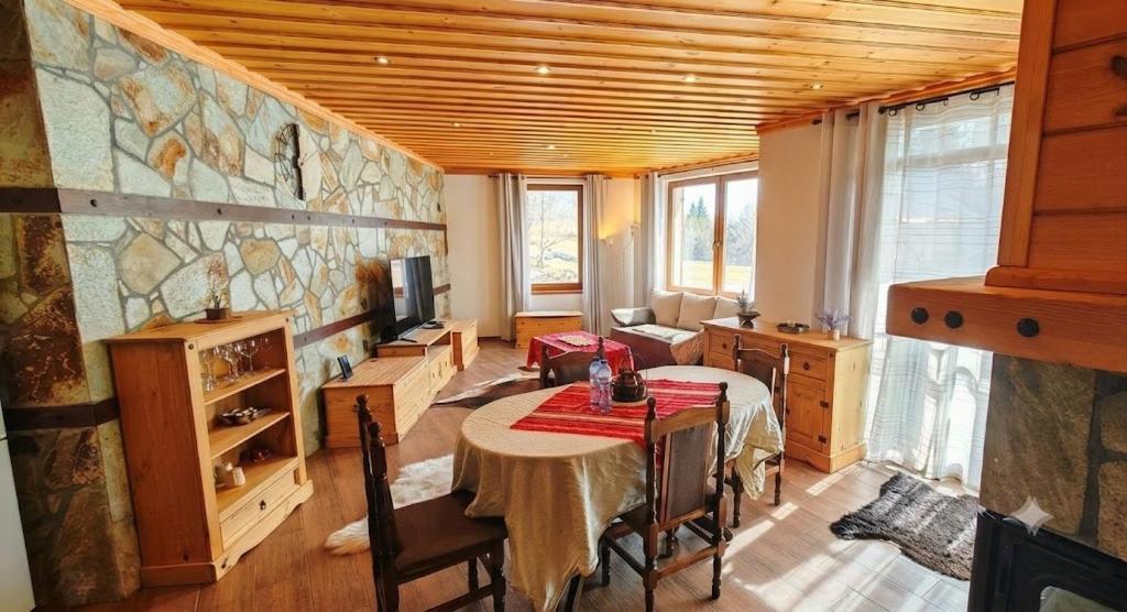 a living room with a table and a tv in a room at Rhodopski Apartment in Chepelare
