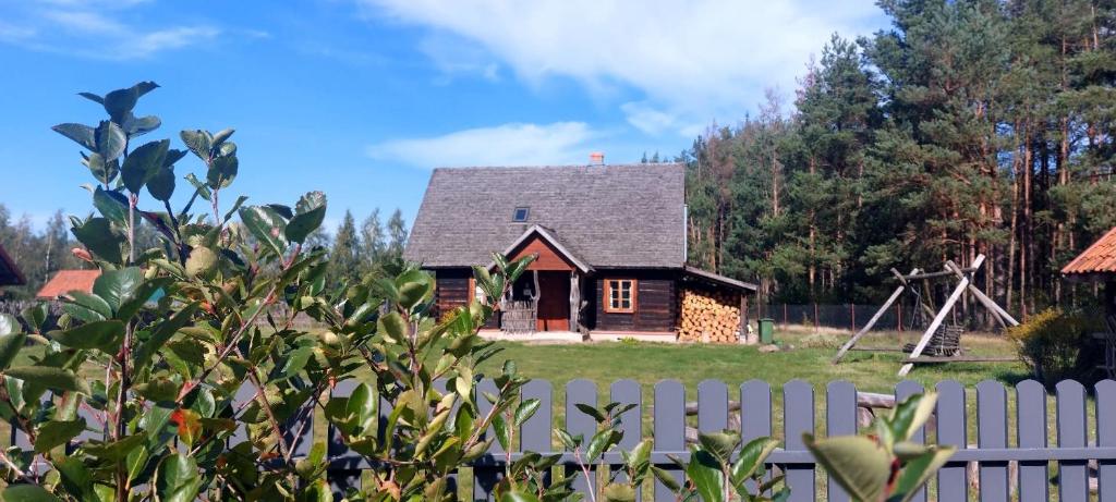 a small house with a fence in front of it at Apartament Janewiczówka in Kopiec