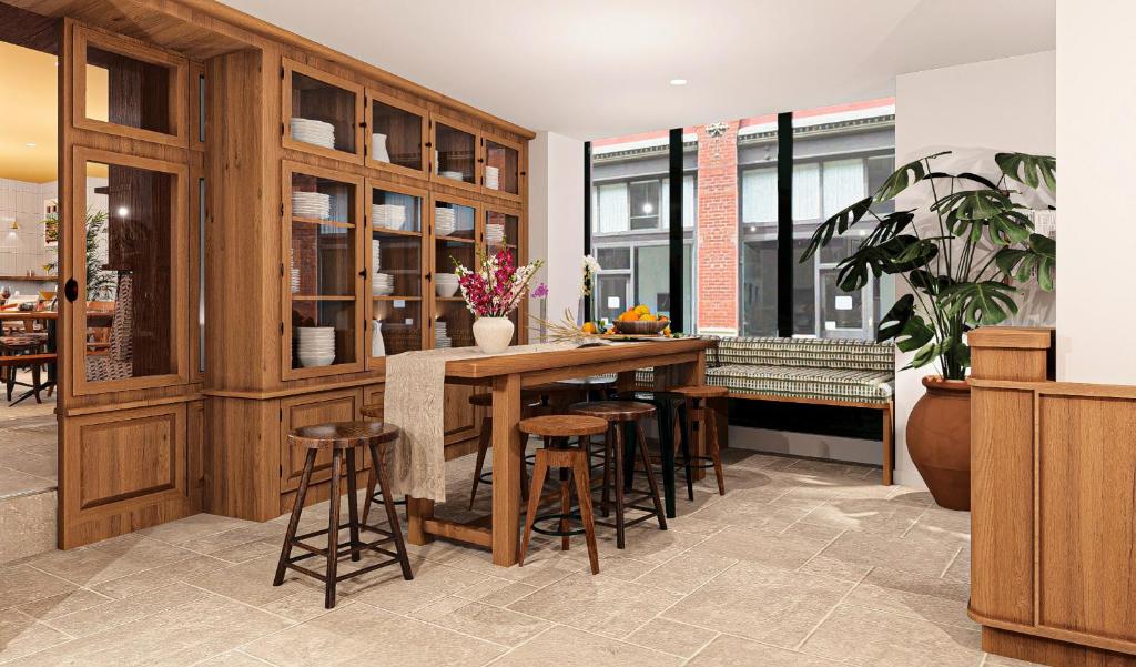 a kitchen with wooden cabinets and bar stools at Alfred Hotels Toulouse Victor Hugo - Hôtel Rénové in Toulouse