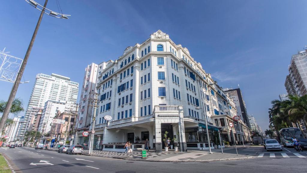 un gran edificio blanco en una calle de la ciudad en Atlântico Hotel, en Santos