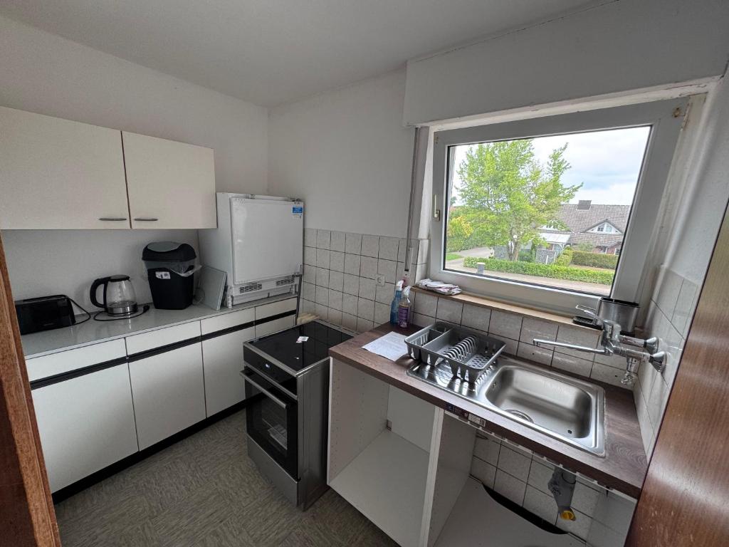 a small kitchen with a sink and a window at Monteur 3P in Fürstenau